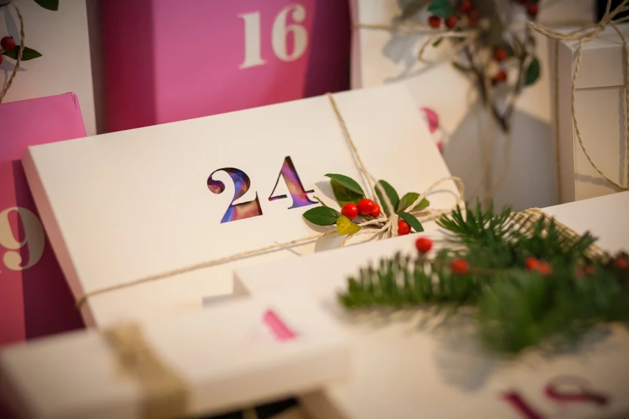 Adventskalender mit stilvollen, nummerierten Geschenkpäckchen, verziert mit Zweigen und roten Beeren – ideal für Technik-Fans.